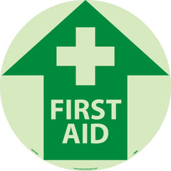 NMC - Adhesive Backed Floor Signs; Message Type: First Aid ; Graphic Type: Cross in Up Arrow ; Message or Graphic: Message & Graphic ; Legend: First Aid ; Color: Green; White ; Special Color Properties: Glow-In-The-Dark - Exact Tooling